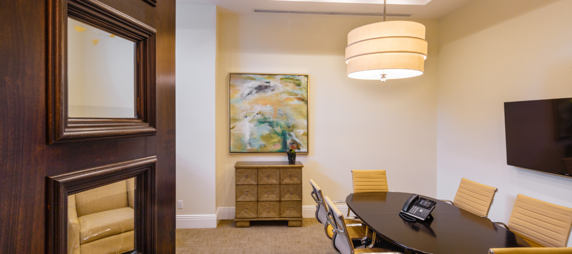 Modern conference room with large table and office chairs.