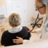 Doctor examining patient with stethoscope.
